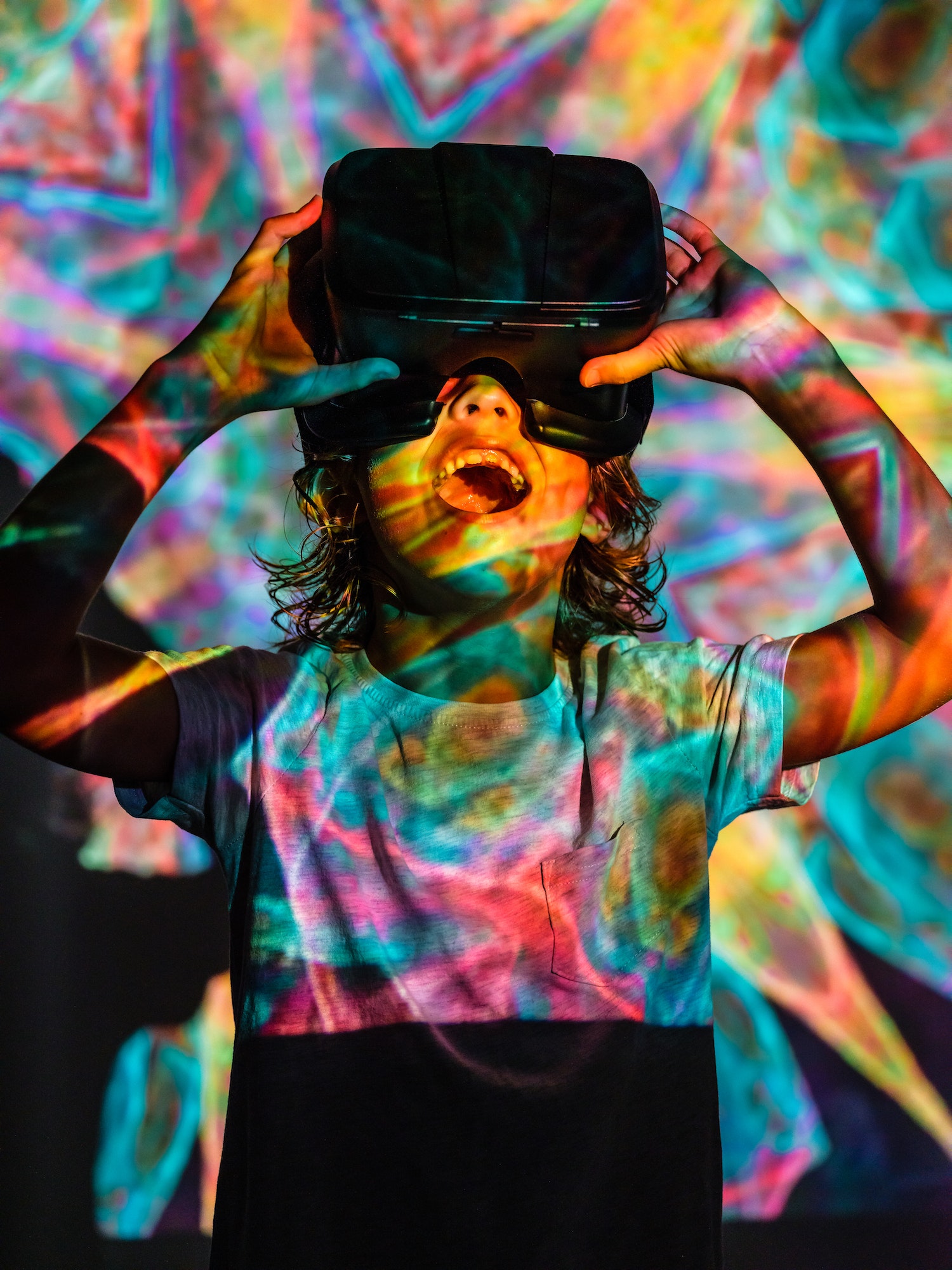Amazed kid in VR headset under neon illumination